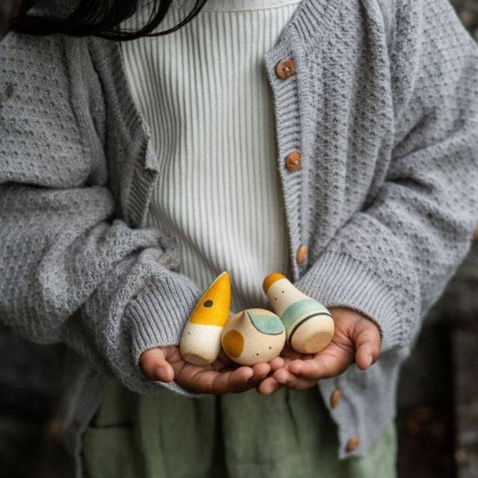 Child holding 3 Hooray! Wooden Humanoid Figures 